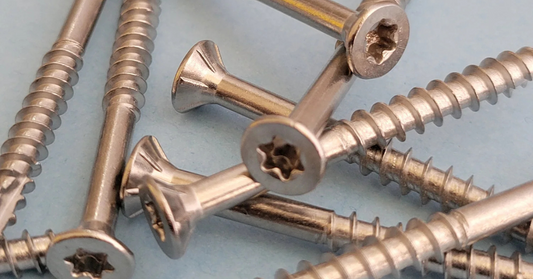Stainless steel screws on a light blue background