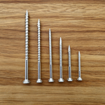 stainless steel eagle claw screws that come in the free sample pack on a wooden surface