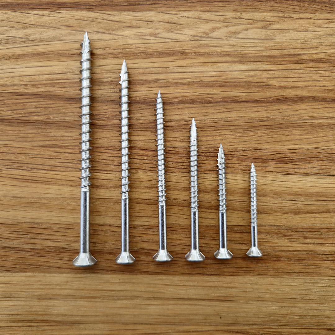 stainless steel eagle claw screws that come in the free sample pack on a wooden surface